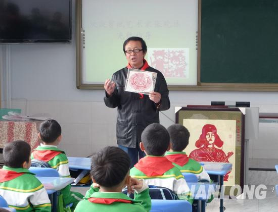 剪纸艺术家张晓林为雷锋小学二年级一班的小学生们上了一堂生动的剪纸课